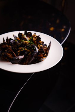 Baharatlı, sarımsak soslu ve otlu kızarmış midyelerin yakın plan görüntüsü.