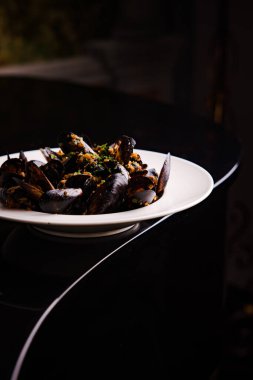 Baharatlı, sarımsak soslu ve otlu kızarmış midyelerin yakın plan görüntüsü.