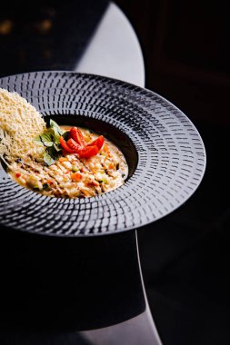 Kuşkonmaz ve domates dilimli leziz kremalı pirinç ahşap arka planda peynirin soyut desenleri.