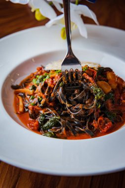 Domates soslu koyu spagetti bolonez ve peynirin soyut deseniyle süslenmiş sarımsak.