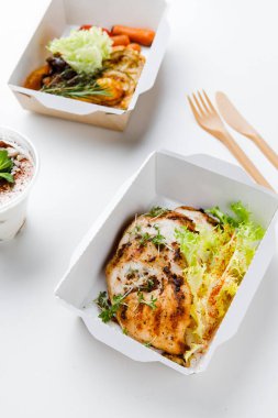 Beslenme çantalarının beyaz arka planda lezzetli yemekleri olan yakın plan görüntüsü.