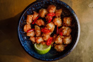 Kırmızı biberli ve limonlu deniz tarağı yakın plan görüntüsü.