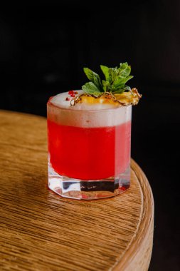 Kurutulmuş ananas dilimi ve naneli taze pembe kokteyl.