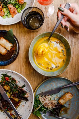 Kabak çorbasının yakın plan görüntüsü ve çeşitli yemeklerle servis edilen bir masa.