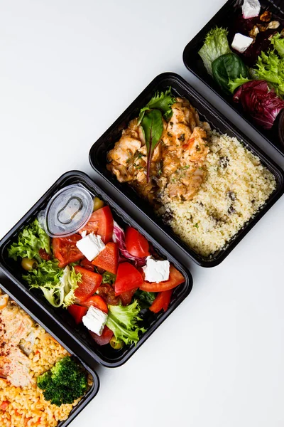 Draufsicht Auf Lunchboxen Mit Verschiedenen Lebensmitteln Und Gemüsesalat Auf Weißem Stockbild