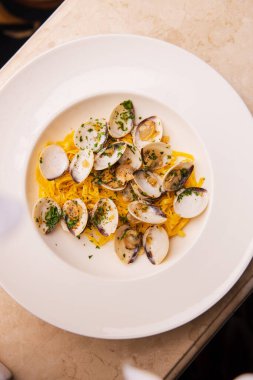 Masada midye, sarımsak ve parmesanlı spagetti resmi.