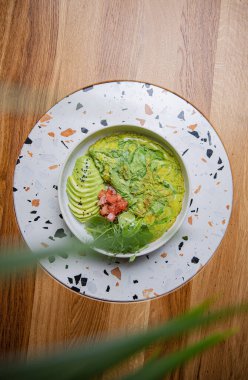 Ispanak ve avokado dilimli omletin en üst görüntüsü.