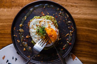 Guacamole ve yumurtalı tostun yakın görüntüsü.