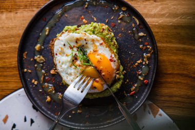 Guacamole ve yumurtalı tostun yakın görüntüsü.