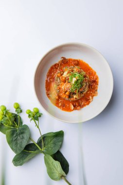 Beyaz tabakta domates soslu lezzetli sebzelerin manzarası. 