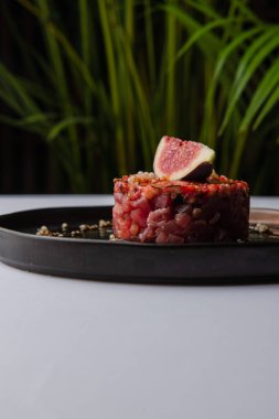 Kırmızı soslu ve incirli Tartarus tabağının yakın görüntüsü.