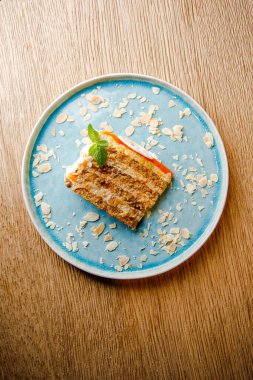 Mavi tabakta beyaz çikolatalı havuçlu kek. 