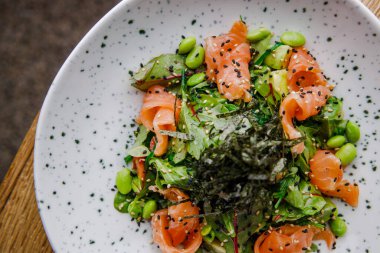 Somon fasulyesi ve yosunlu lezzetli salata tabağının yakın görüntüsü.