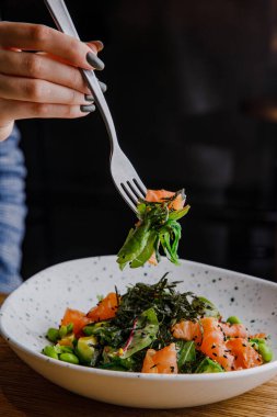 Somon fasulyesi ve yosunlu lezzetli salata tabağının yakın görüntüsü.