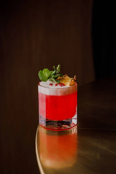 pink fresh cocktail with dried pineapple slice and mint