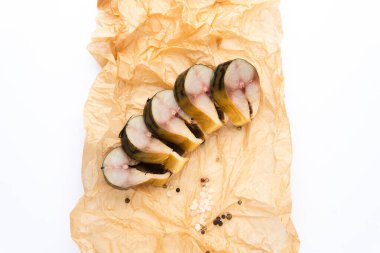 Beyaz arka planda buruşmuş kağıt üzerinde tütsülenmiş balık parçalarının üst görünümü