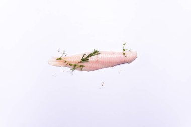 Beyaz arka planda yalıtılmış otlu beyaz balık filetosu üst görünümü 