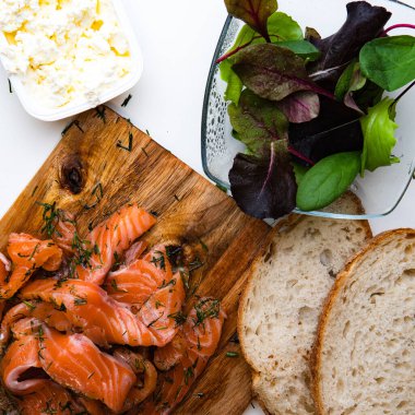 Beyaz arka planda somon, domates ve sebzelerle bruschetta yapmak için gerekli malzemelerin yakın plan görüntüsü