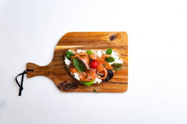 Beyaz arka planda somon, domates ve sebzeli bruschetta manzarası