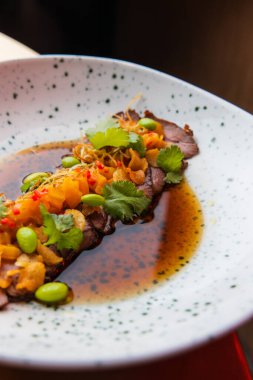 Soslu peynirli bifteğin yakın plan görüntüsü.