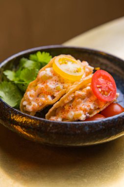 Taco, maydanoz ve domates dilimlerinin yakın plan görüntüsü.