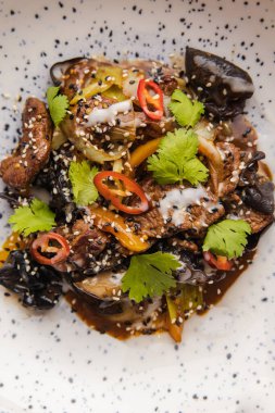 Mantarlı ve biftekli kızarmış sebzelerin yakın plan görüntüsü