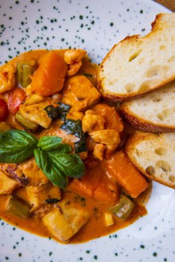 Deniz ürünleri ve ekmek dilimleriyle pişirilmiş sebzelerin yakın plan görüntüsü.