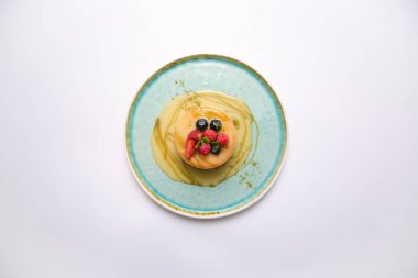 Taze ahududu, yaban mersini ve tatlı soslu krep manzarası. 