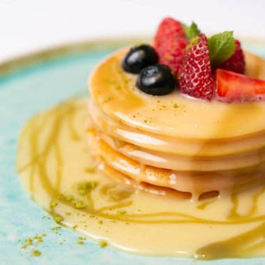 Taze ahududu, yabanmersini ve tatlı soslu krep. 