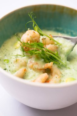Sebze çorbası ve karidesli püre kasesinin yakın görüntüsü.