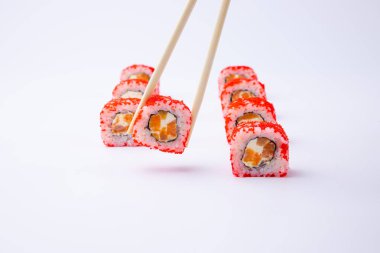 Beyaz zemin üzerinde yemek çubukları olan Japon suşisi seti.