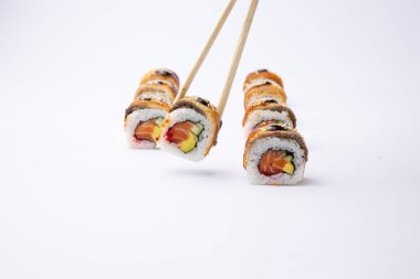 Beyaz zemin üzerinde yemek çubukları olan Japon suşisi seti.