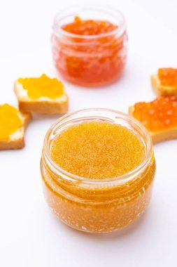  Kırmızı havyar kavanozları, tereyağlı tostlar ve beyaz arka planda farklı türde kırmızı havyar.