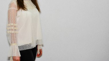 Duvarda sıradan kıyafetler giyen bir kadın. 