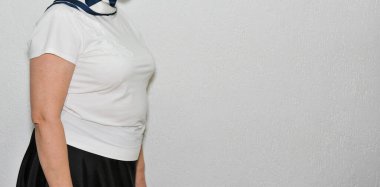 Duvarda sıradan kıyafetler giyen bir kadın. 