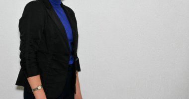 Duvarda sıradan kıyafetler giyen bir kadın. 