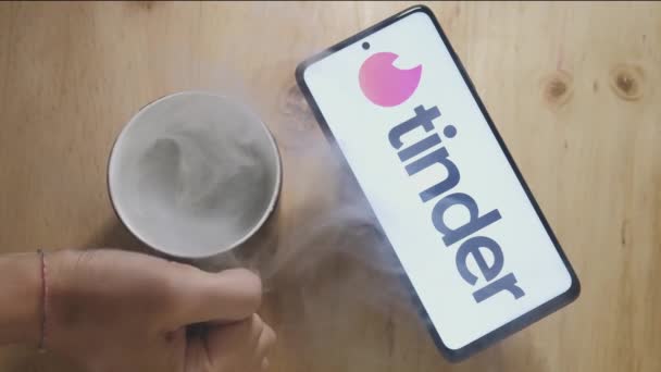Tinder Logo Auf Einem Android Smartphone Mit Einer Heißen Tasse — Stockvideo