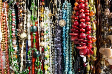 İnci, tohum, taş ve diğer malzemelerle dolu çok sayıda kolye. Farklı şekiller, renkler ve boyutlar.