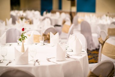 Düğün töreni için şık bir masa, boş şarap bardakları, çatal bıçak, çatal, peçete ve buket restoranda.