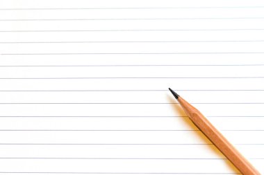 Boş çizgili bir defter kağıdındaki boş bir kalemin en üst görünümü
