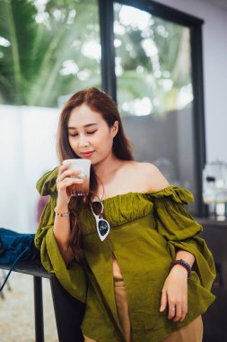 Kahvesini içen Asyalı kadın.