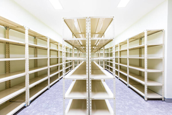 Empty white metal shelves in storage room