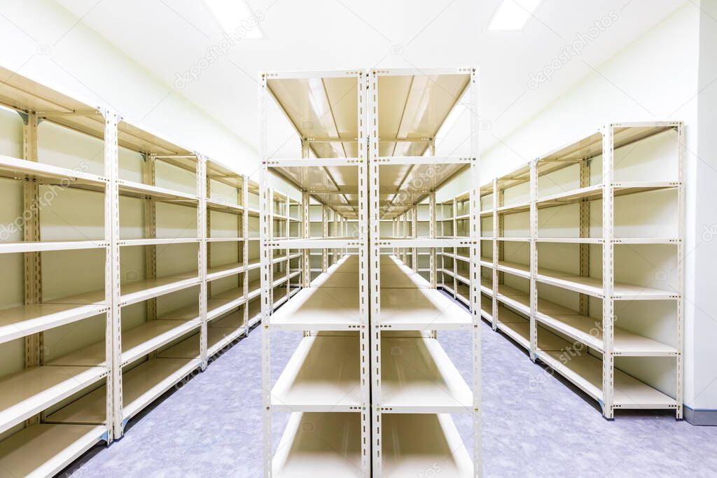 Empty white metal shelves in storage room