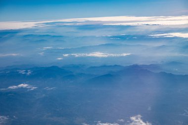 Bulutların üstündeki hava manzarası ve uçaktan dağa