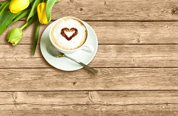 Kartkę z życzeniami z filiżanką kawy i żółte tulipany — Zdjęcie stockowe