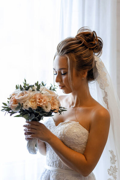 Портрет счастливой невесты с букетом цветов в день свадьбы.