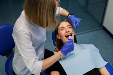 Diş hekimi hastaya diş teli takar. Yakın plan.