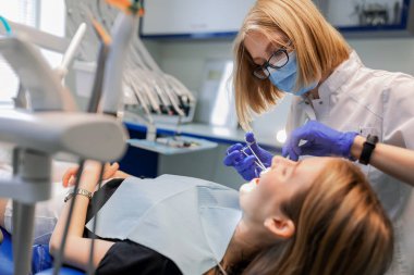 Diş hekimi hastaya diş teli takar. Yakın plan.