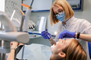 Diş hekimi hastaya diş teli takar. Yakın plan.