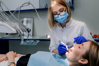 Diş hekimi hastaya diş teli takar. Yakın plan.